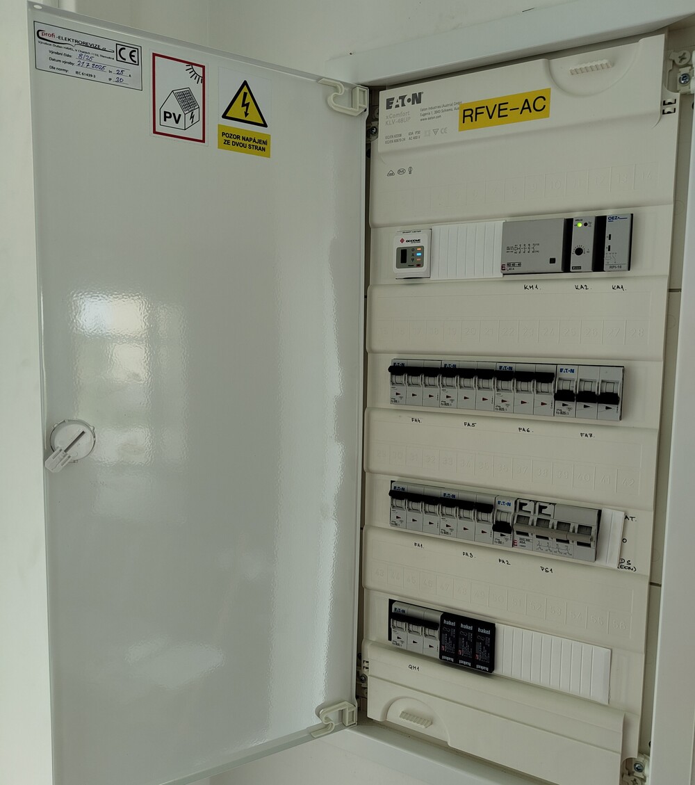 Detailní pohled na úhledně zapojený AC rozvaděč fotovoltaické elektrárny s bezpečnostními prvky.